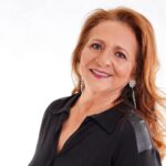 Smiling Woman Wearing Earrings and Black Collared Top